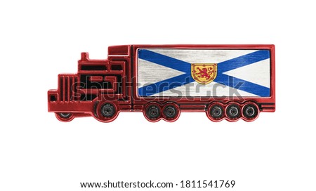 Toy truck with Nova Scotia flag shown isolated on white background. The concept of cargo transportation between countries.