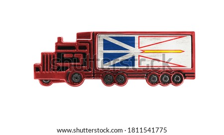 Toy truck with Newfoundland and Labrador flag shown isolated on white background. The concept of cargo transportation between countries.