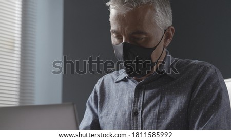 Professional businessman working in the office during coronavirus pandemic, he is wearing a face mask