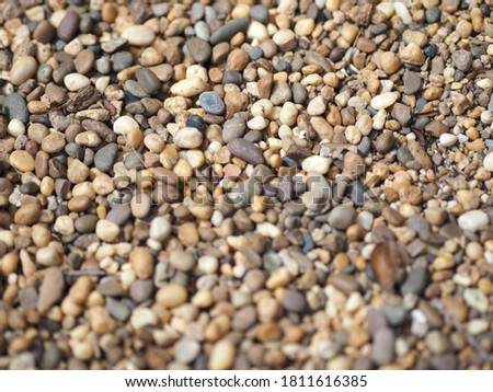 select focus blurred Background of small pebbles round sea stones texture rocks material