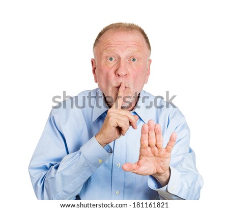 Closeup portrait of senior mature serious man placing finger on lips as if to say, shh, be quiet, isolated white background. Negative facial expression, human emotions sign, symbols, body language.
