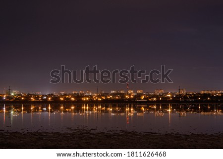 city lights at night behind a pond on long exposure