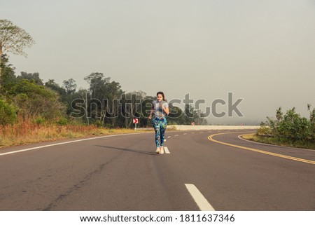 Woman running on the road. Jungle landscape. Concept of health and sport.