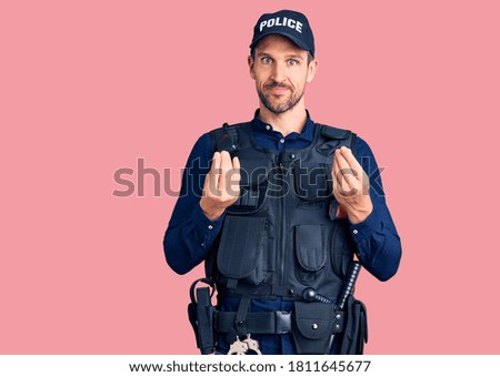 Young handsome man wearing police uniform doing money gesture with hands, asking for salary payment, millionaire business 