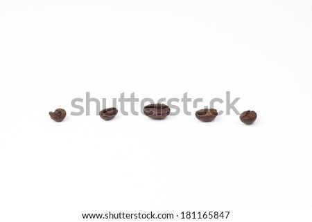 Five roasted coffee beans on white background