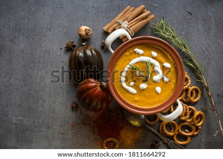 Roasted butternut squash soup with creamy sauce and rosemary. Healthy vegan dinner top view photo. Halloween dinner ideas. 