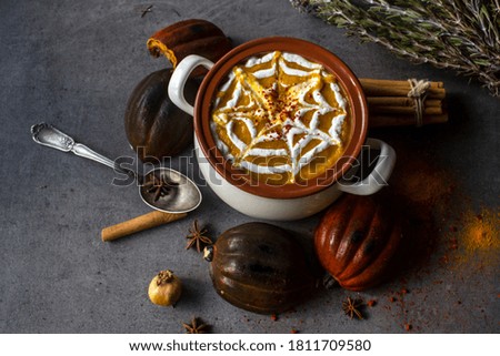Roasted butternut squash soup with creamy sauce and rosemary. Healthy vegan dinner top view photo. Halloween dinner ideas. 
