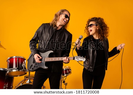 Famous artist two people recording sound solo song woman sing event party night club man play bass guitar wear leather black jacket sunglass isolated over bright shine color background