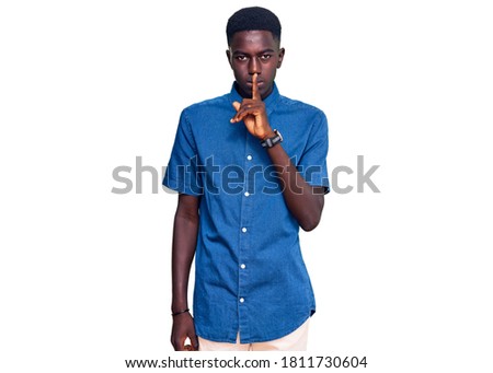 Young african american man wearing casual clothes asking to be quiet with finger on lips. silence and secret concept. 