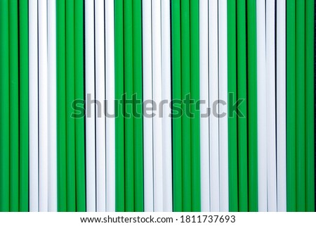 top view of green and white plastic drinking  straws in a row
