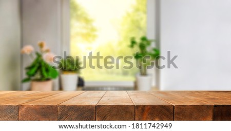 Wooden brown table of free space and blurred home interior with window 