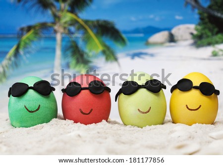 Four easter eggs with sunglasses on ocean beach  Royalty-Free Stock Photo #181177856