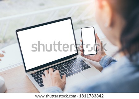 computer,cell phone mockup.hand woman work using laptop texting mobile.blank screen with white background for advertising,contact business search information on desk in cafe.marketing,design