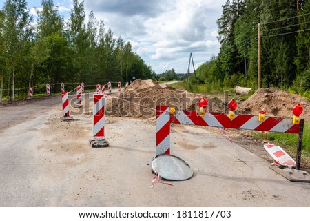 Road outside the city with warning signs about repairs. One lane is closed. Traffic safety. Arrangement of drainage and drainage system near roads. Improving road quality. Latvia