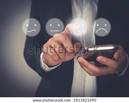 Customer Experience Concept,  Business people holding the smartphone with a checked box on Excellent Face and Rating for a satisfaction survey.
