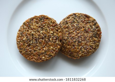 Vegan burger patties made from quinoa, lentils and beans on a wooden cutting board. This photo has selective focus. 