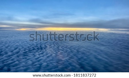 Cumulus clouds with a band of the setting sun on the horizon over the Arctic ocean