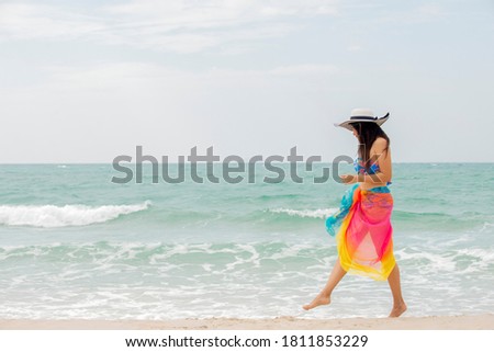 Relax  traveler  asian woman  in bikini with sun hat walking  on the beach   enjoys on vacation , Travel  holiday  lifestyle  summer healthy  beuthy Concept , Banner for text