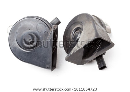 Pair of electric black plastic horns in retro style - car horn on white isolated background in photo studio. Spare part for sale or repair in a workshop, or tuning a buzzer sound in car service.