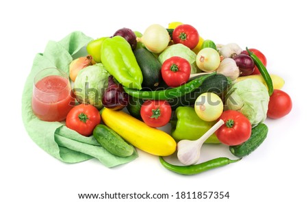 A set of fresh vegetables in a large assortment, a glass of vegetable juice, a green branch and a linen napkin on a white background with water drops. The concept of natural products, proper nutrition