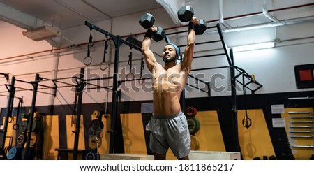 strong young guy lifting weights in gym