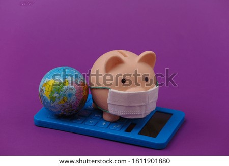 Piggy bank with medical mask and calculator, globe on purple background. Economic disease. Financial crisis. Covid-19 pandemic
