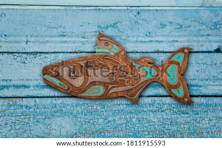 Wooden native salmon on blue background. Home decor. Plywood, laser cut