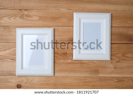 White photo frames on wooden background



