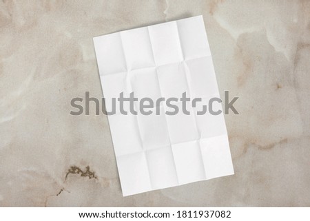 Blank white crumpled and creased poster mockup on marble wall background