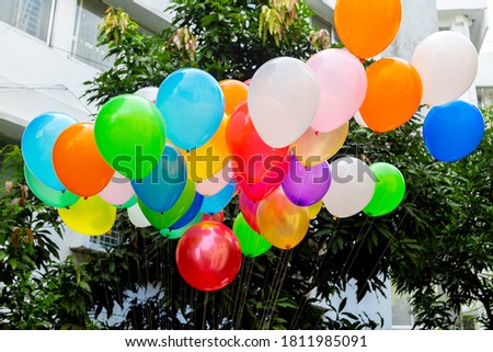 Colorful balloons filled with gas tied to the thread are flying.