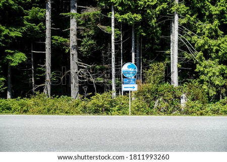 A tsunami evacuation route sign along a road on Vancouver Island outside of Tofino, British Columbia, Canada.