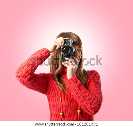 Girl taking a picture over pink background 