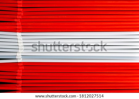 Top view of red and  white  plastic drinking straws in a row. Colours of flag of  Austria 