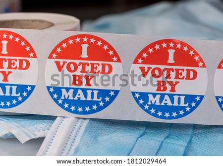 I Voted by Mail sticker on protective face mask for absentee ballot or mail-in voting in the presidential election during coronavirus pandemic Royalty-Free Stock Photo #1812029464