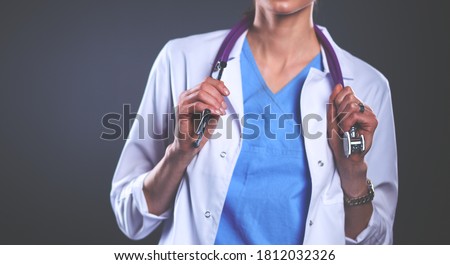 Young doctor woman with stethoscope isolated on grey