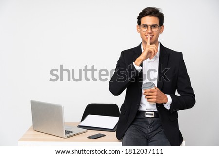 Businessman in his office over isolated white background doing silence gesture