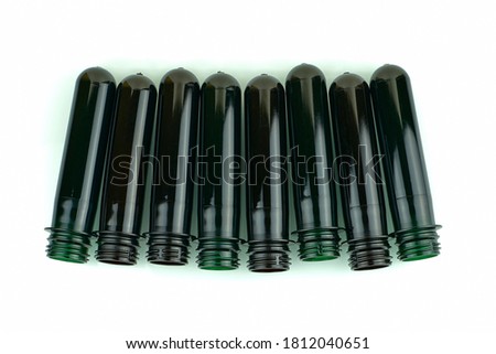 PET preforms, top view. Blanks for a plastic bottle, on a white background. Plastic blanks for blowing bottles. Green and brown plastic bottle preforms