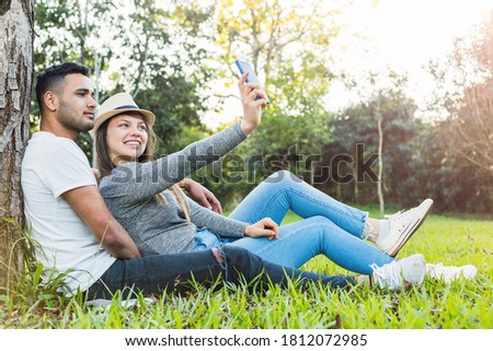 Young couple takes a picture.  Cool couple in the park.  Concept of love and outdoor.