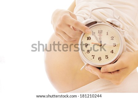 The pregnant woman on a white background with a clock