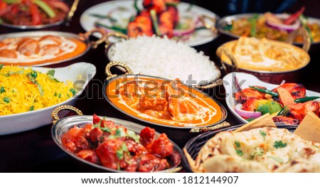 Indian food Curry butter chicken, Palak Paneer, Chiken Tikka, Biryani, Vegetable Curry, Papad, Dal, Palak Sabji, Jira Alu, Rice with Saffron on dark background Royalty-Free Stock Photo #1812144907