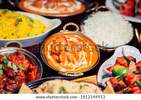 Indian food Curry butter chicken, Palak Paneer, Chiken Tikka, Biryani, Vegetable Curry, Papad, Dal, Palak Sabji, Jira Alu, Rice with Saffron on dark background Royalty-Free Stock Photo #1812144913