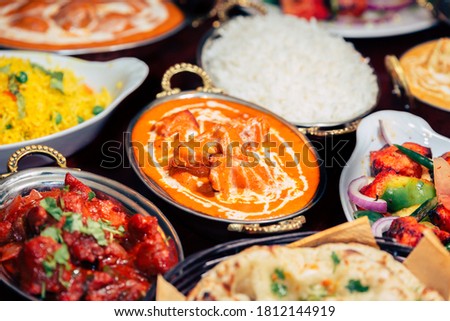 Indian food Curry butter chicken, Palak Paneer, Chiken Tikka, Biryani, Vegetable Curry, Papad, Dal, Palak Sabji, Jira Alu, Rice with Saffron on dark background Royalty-Free Stock Photo #1812144919