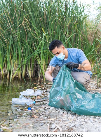 Close Up of Person Collecting Plastic From the River. Man Cleaning River of Plastics. Environment Concept. Royalty-Free Stock Photo #1812168742