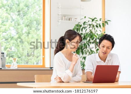 Asian couple looking at a computer in the living room