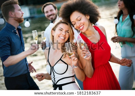 Group of happy friends drinking champagne and celebrating New Year