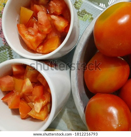 Tomato chunk in the mugs with fresh tomato in a bowl