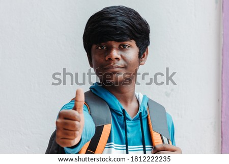 Portrait of an Indian school kid  giving thumbs up in front of the camera