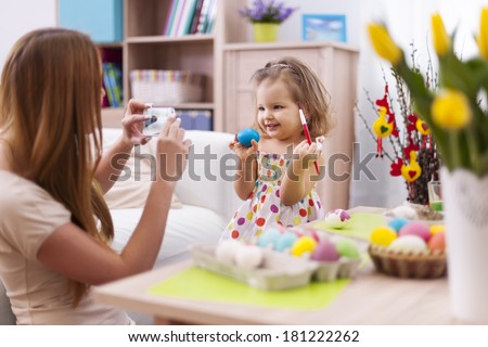 Proud mother take a picture her daughter with easter egg 