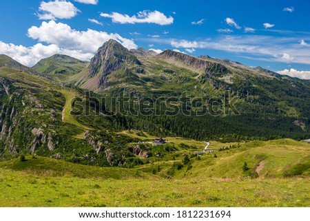 Panorama picture over Passo Rolle in the Italian Alps and the surrounding meadows, forests and Dolomite peaks taken at the end of summer. Trentino, Italy