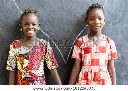 Gorgeous African Sisters Posing, Smiling and Laughing Happy in Front of Blackboard at School